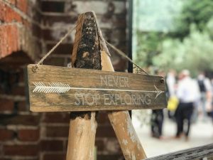 Rustic wood sign with 'Never Stop Exploring' in York, England.